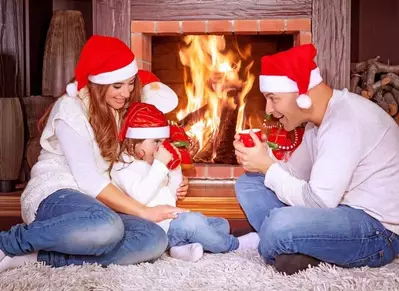 Happy family celebrating Christmas in front of the fireplace in a cabin.